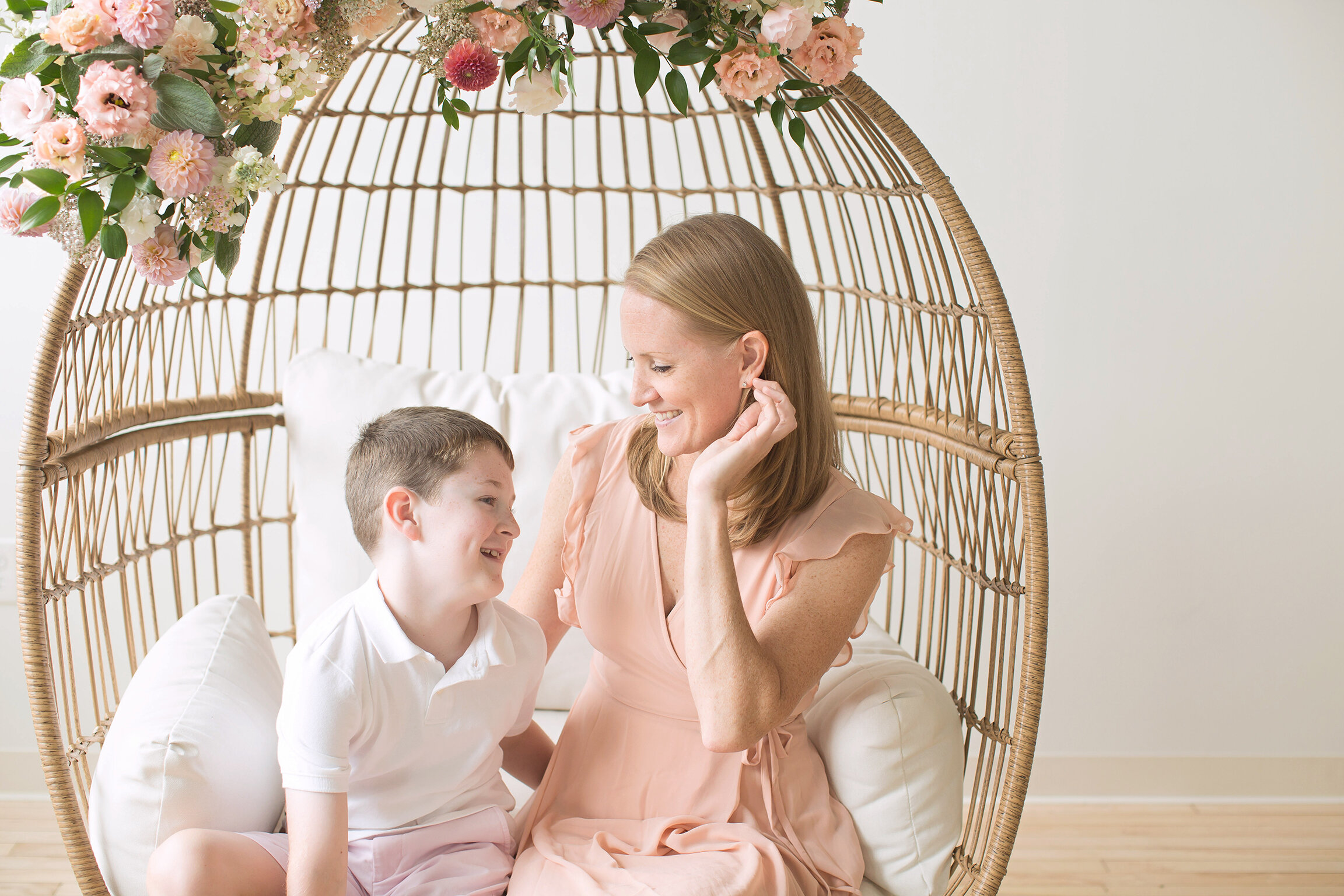 Philadelphia newborn photographer mom sitting with son in floral chair