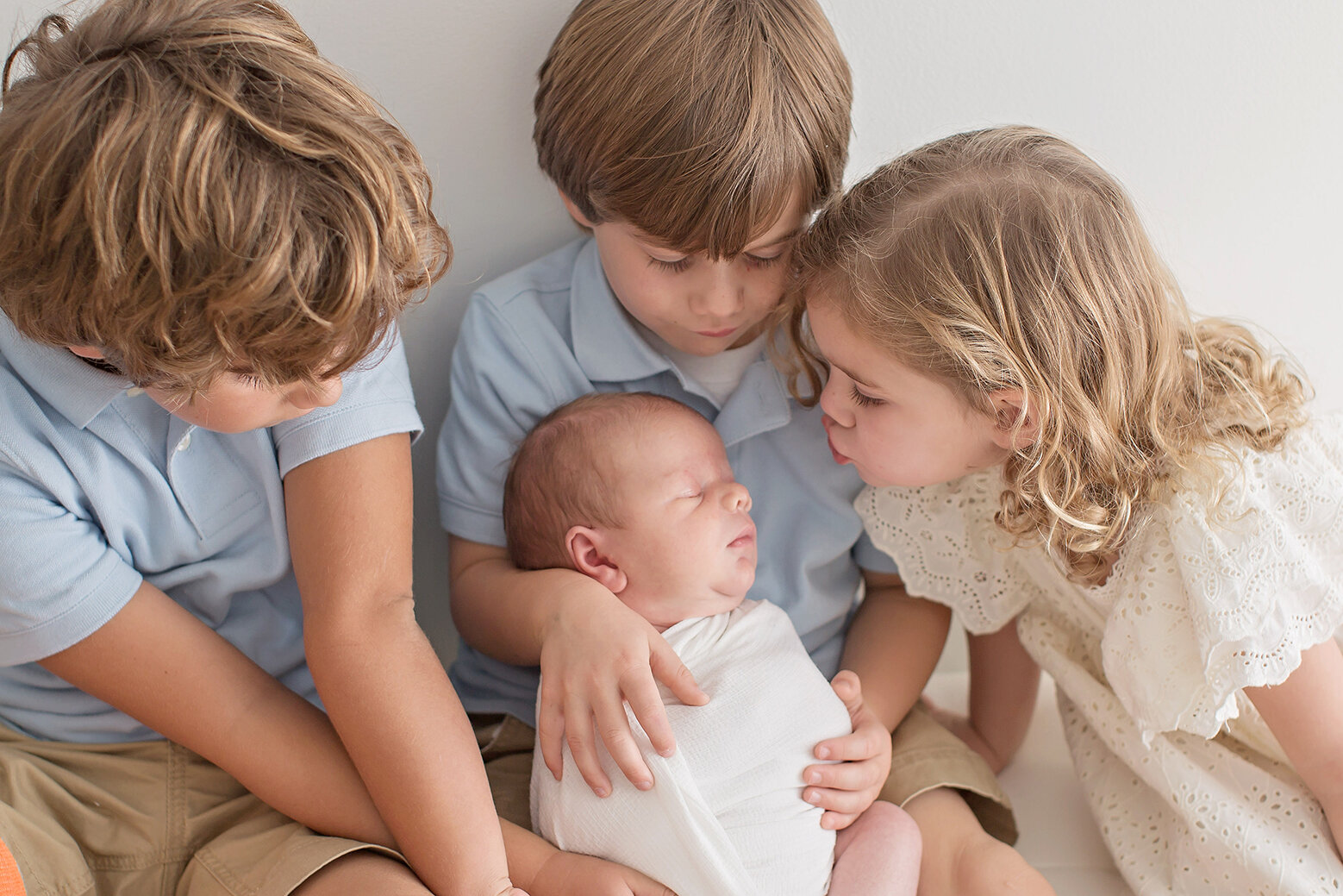 siblings kissing baby brother philadelphia pa Newborn Photographer