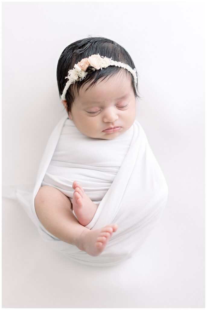 baby girl swaddled in white blanket newborn portrait