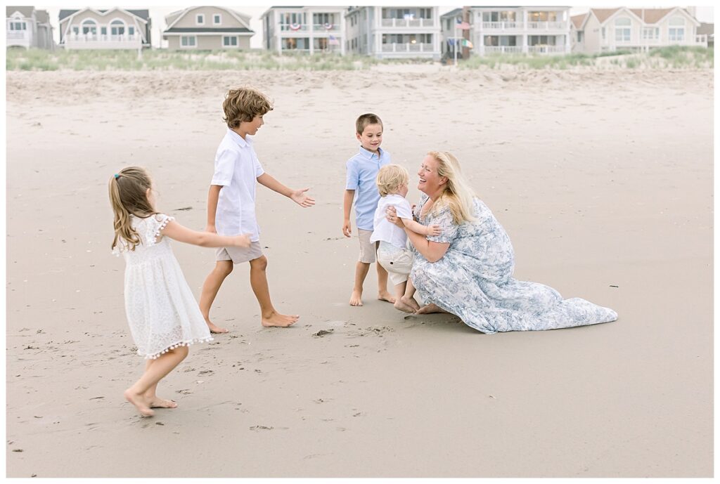 kids lovingly running to mom on OCNJ beach for family portraits