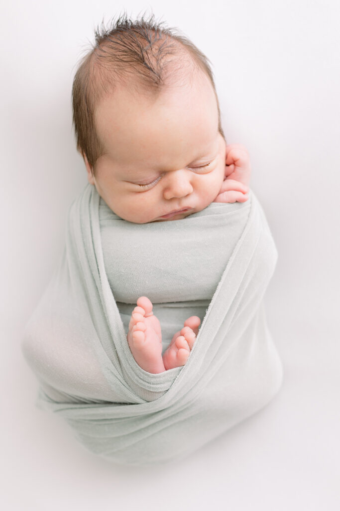 baby boy wrapped in swaddle newborn photos