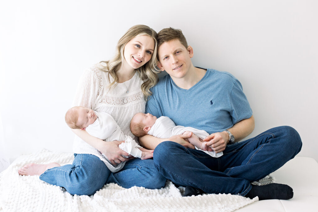 mom and dad holding twins newborn photography session