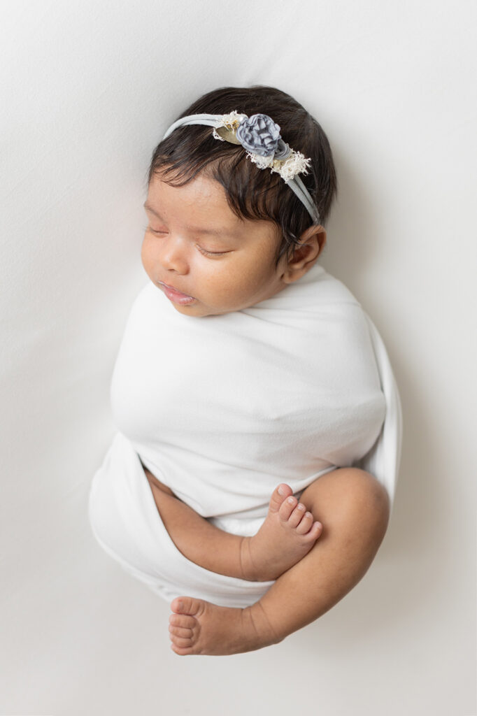 baby girl swaddled white blanket headband newborn photography philadelphia