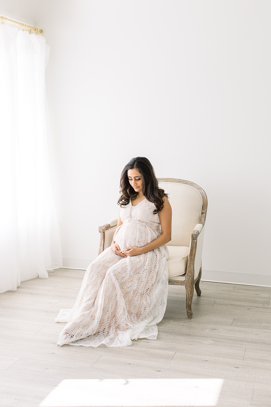 pregnant women in dress sitting in chair maternity pictures