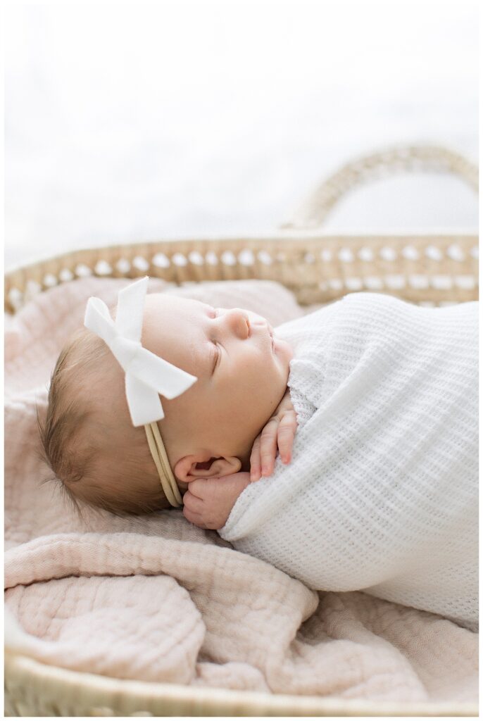 newborn baby in moses basket white headband