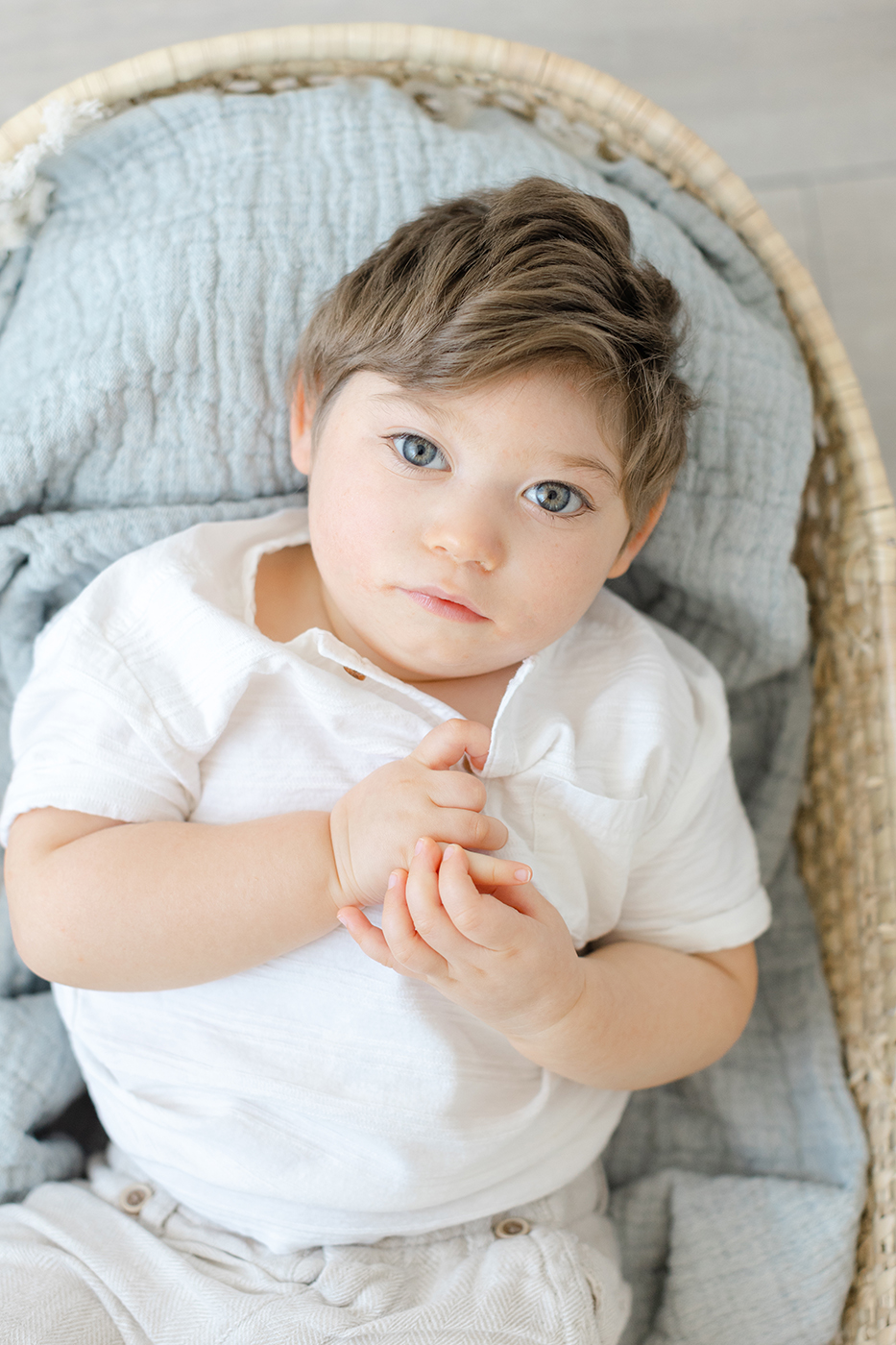 baby with blue eyes in moses basket 