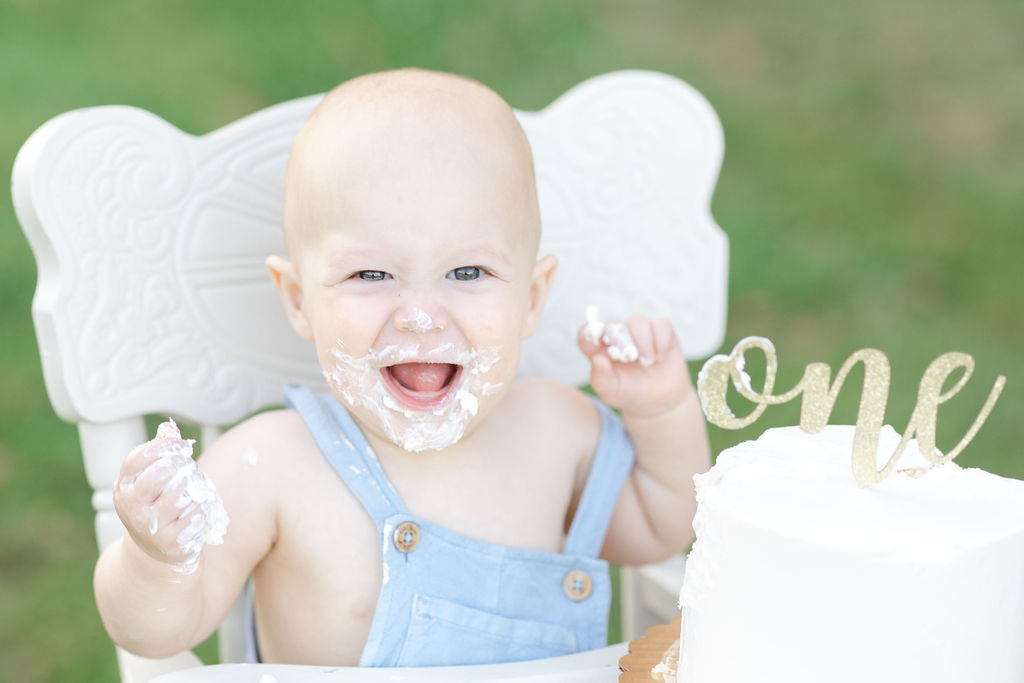 A one year old laughs and plays with cake as it smashes it from a bakery in Newtown PA
