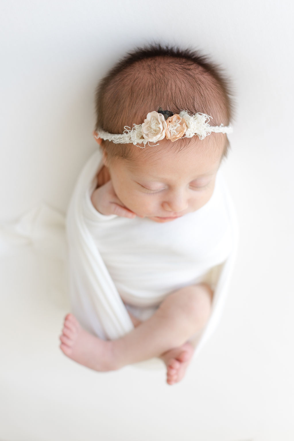 Details of a newborn baby's head with a floral headband taken by a bucks county newborn photographer