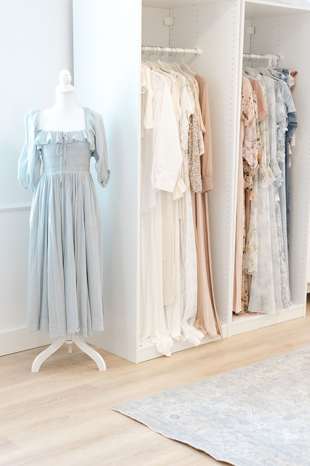 Details of dresses hanging in a Doylestown Maternity studio with a blue dress on a manikin