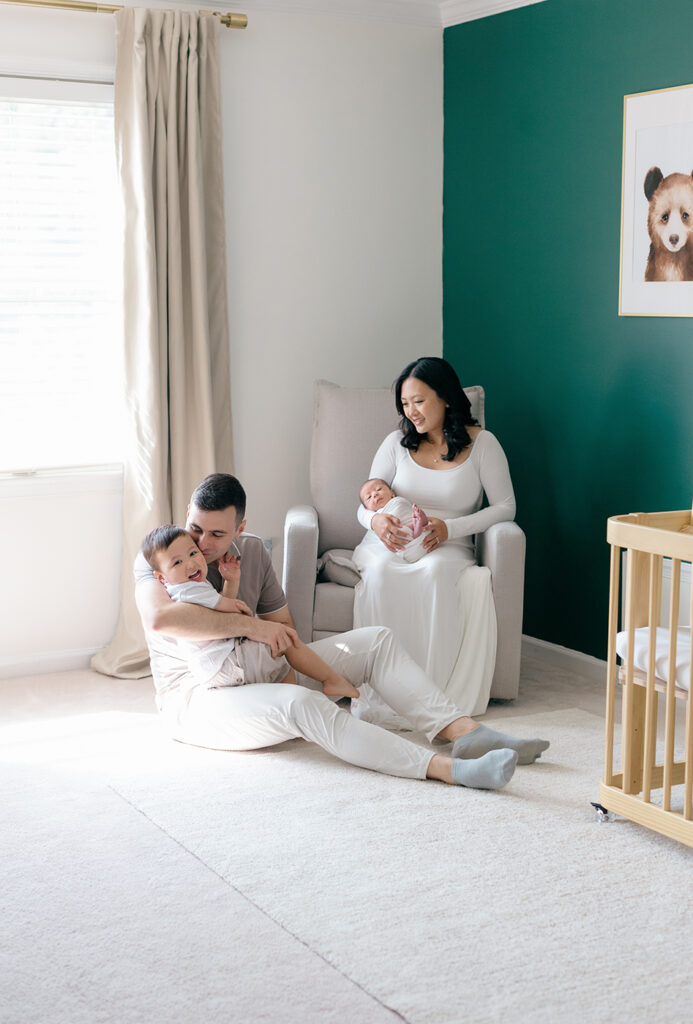family of four in newborn green nursery