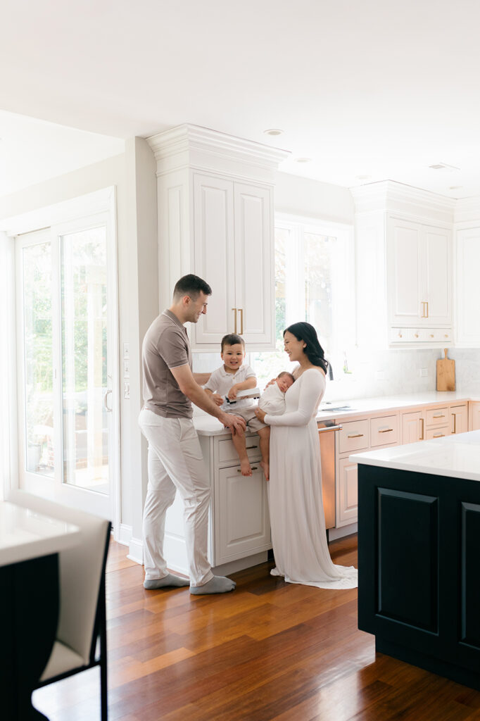family of four in kitchen new baby