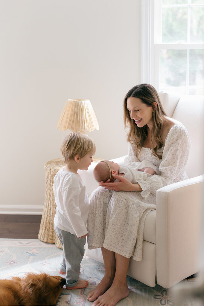 mom holding baby toddler kissing brother newborn photography