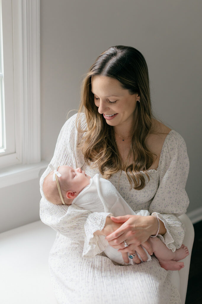 mom in white floral dress holding newborn