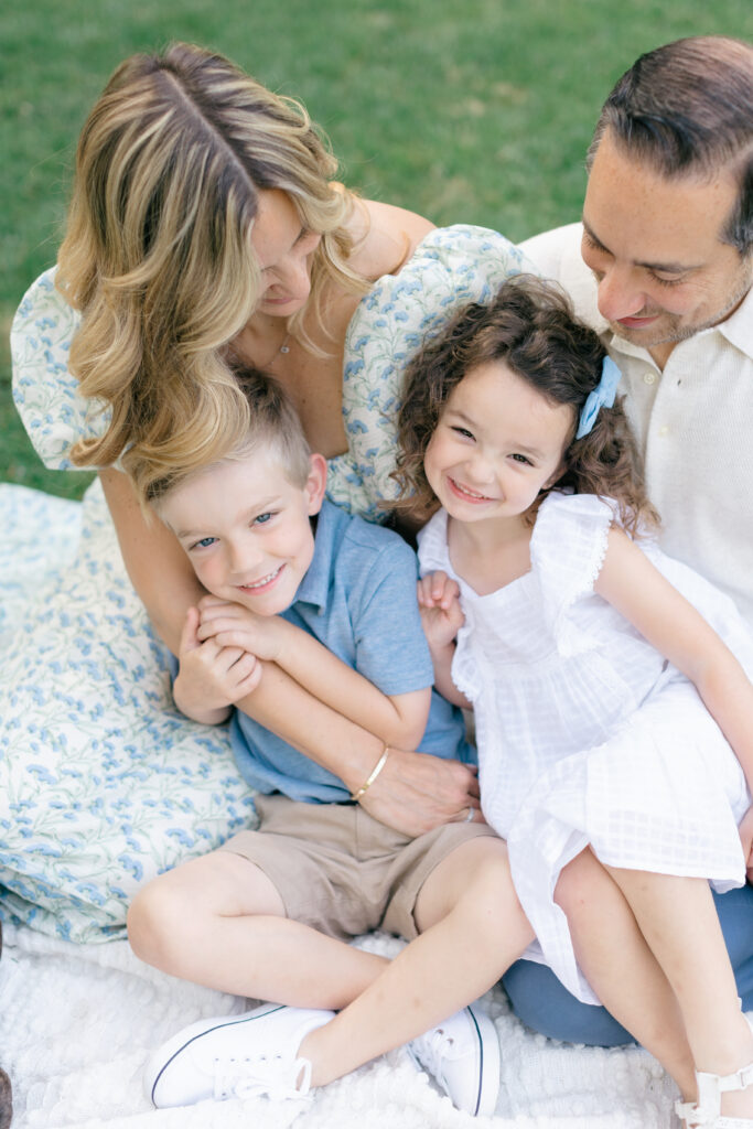 spring photos family snuggling on blanket on grass with dog