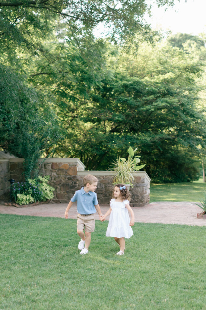 siblings walking together on grass