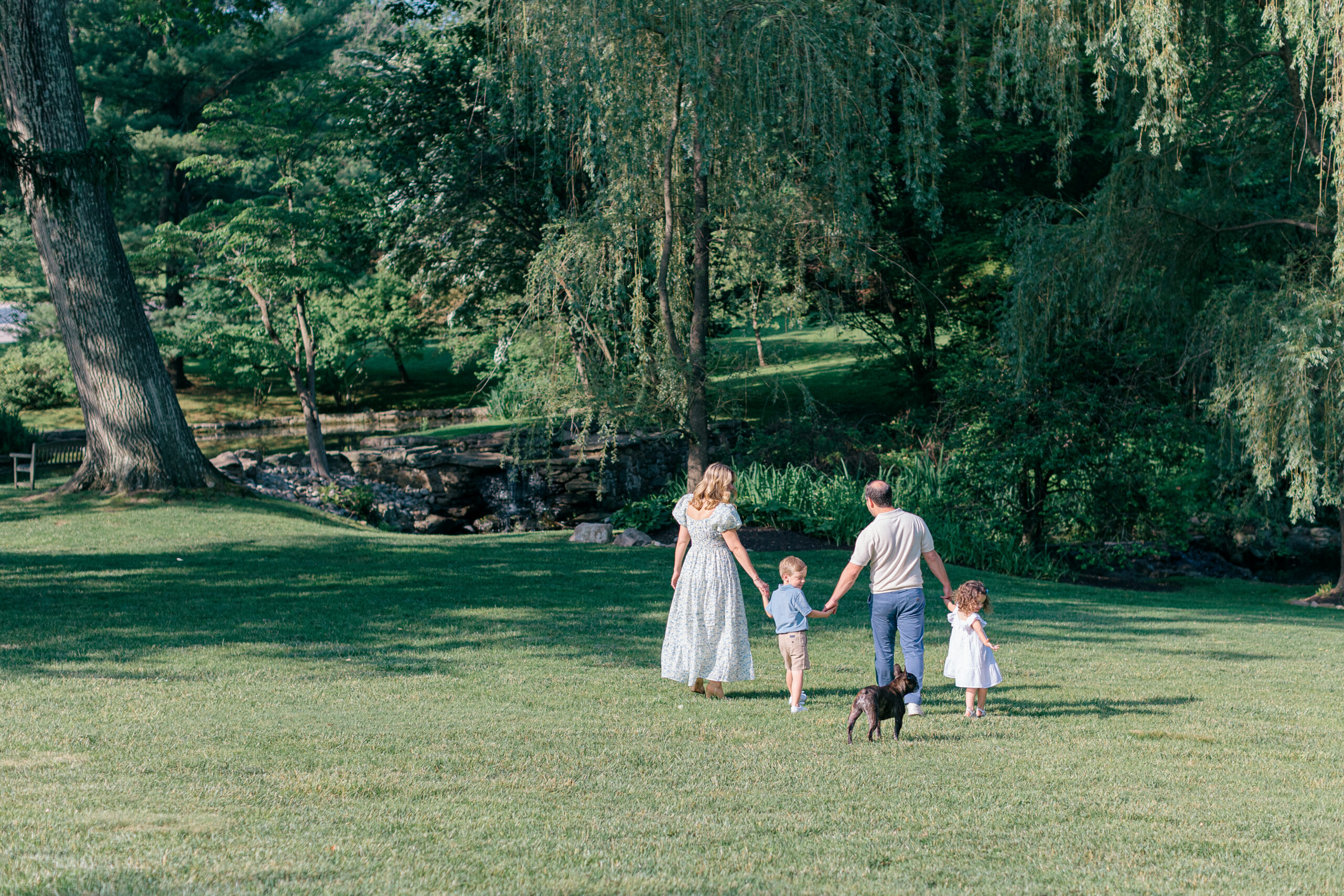 family walking together trees grass
