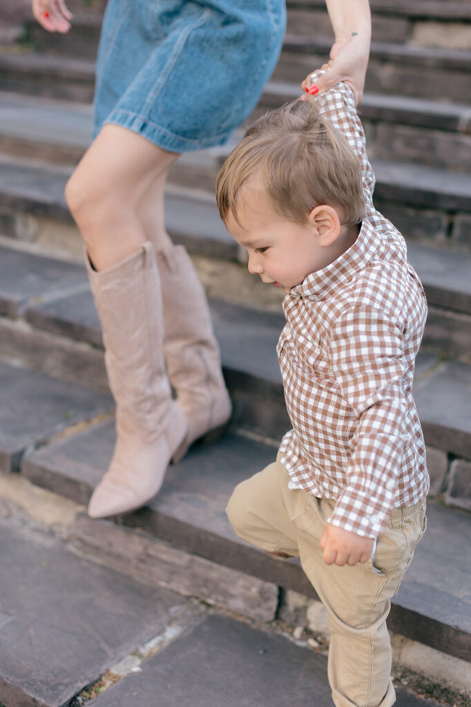 boy in plaid shirt holding mom's hand